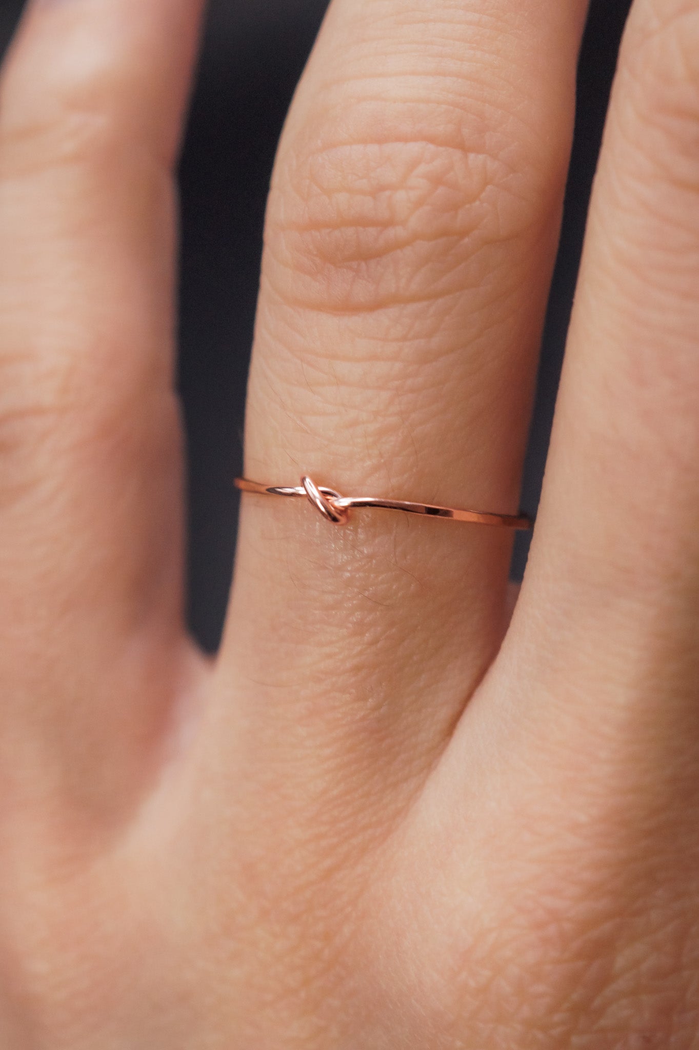 Modeled example of the Ultra Thin Closed Knot in 14k Rose Gold Fill on the ring finger.