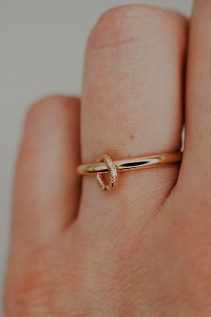 Gold ring on a finger with a plain background