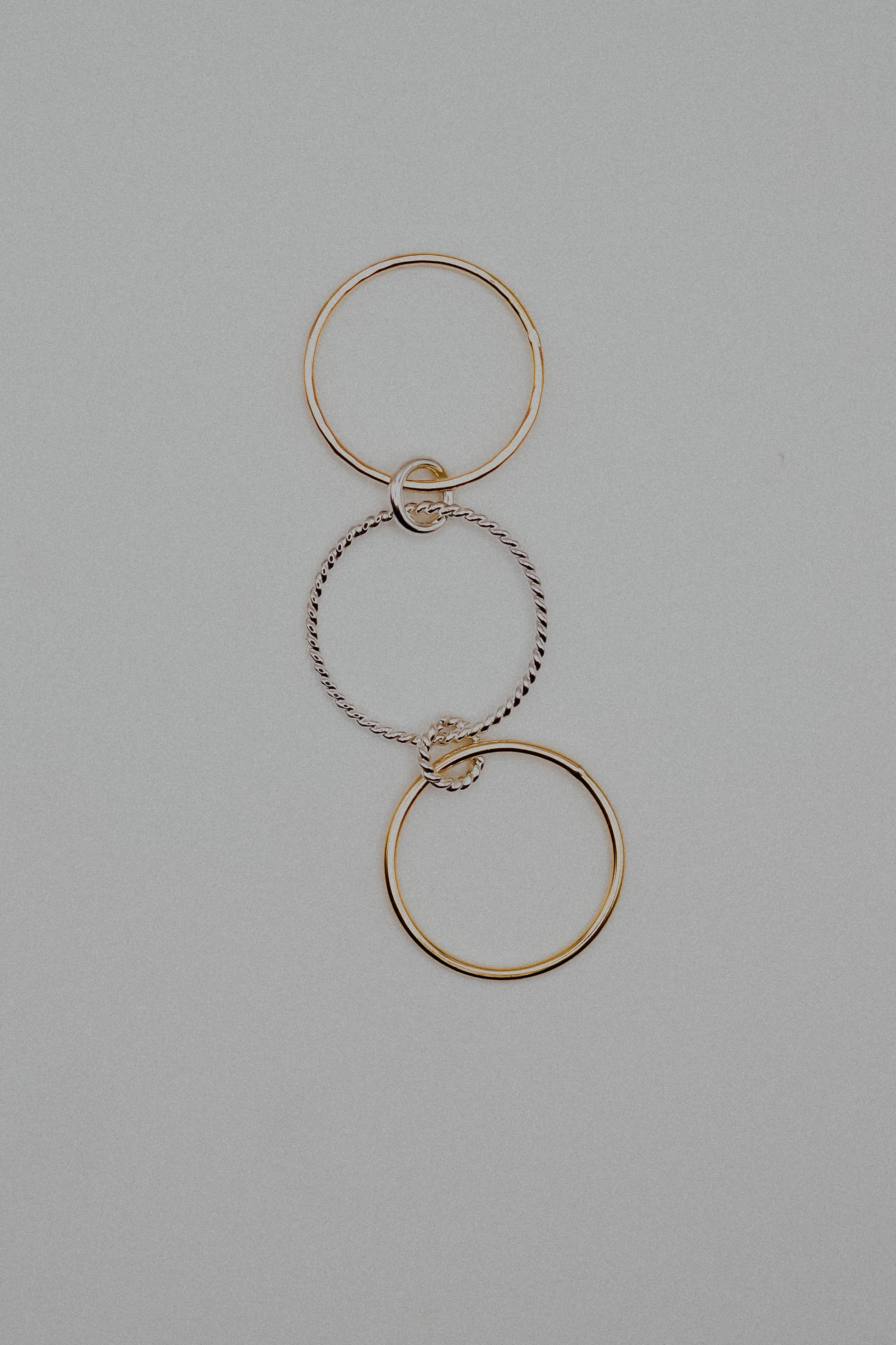 Gold and silver interlocking rings on a gray background