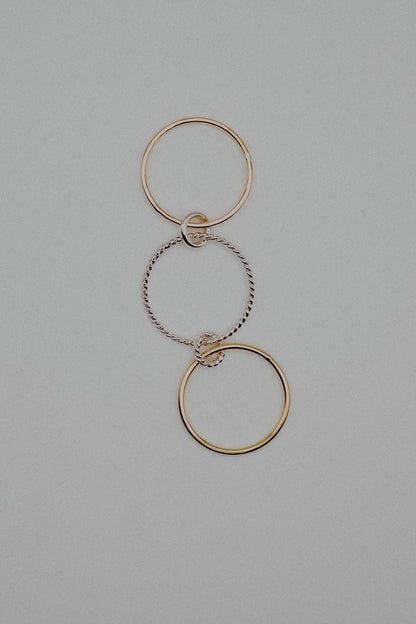 Gold and silver interlocking rings on a gray background